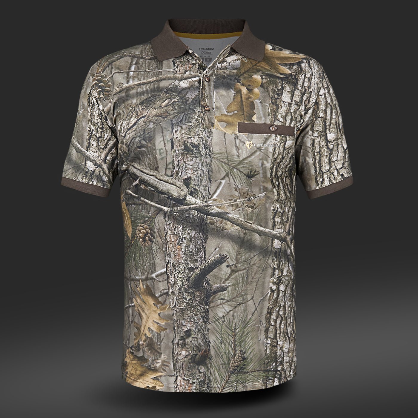 Das Hillman Poloshirt Kurzarm – DGT Baumwolle Polo Jagd T-Shirt besticht durch ein Camouflage-Design mit Baumrinde, Blättern und Tannenzweigen. Es verfügt über Digitaldruck-Technologie, einen dunklen Kragen und eine geknöpfte Brusttasche auf einfarbigem grauem Hintergrund für modernen Flair.