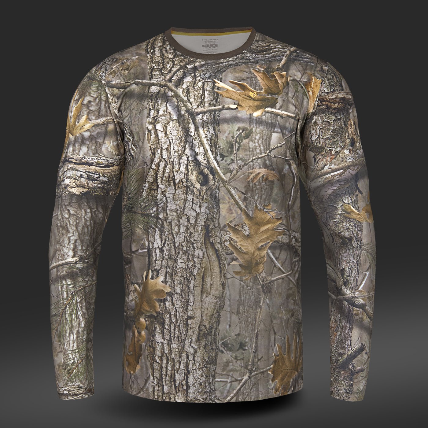 Das Baumwoll-T-Shirt Langarm von Hillman verfügt über ein Baumrinden- und Blatt-Tarnmuster aus hautfreundlicher ägyptischer Baumwolle vor einem dunklen Hintergrund.
