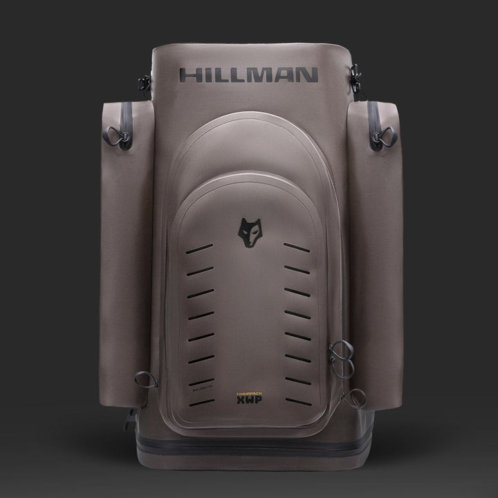 Der schlichte, graue Hillman Sitzrucksack - Wasserdichter Jagd Rucksack Stuhl XWP40 steht aufrecht vor einem dunklen Hintergrund und präsentiert sich mit mehreren Fächern, Seitentaschen und einem Wolfslogo. Dieser moderne Rucksack vereint minimalistisches Design mit bester Outdoor-Performance.