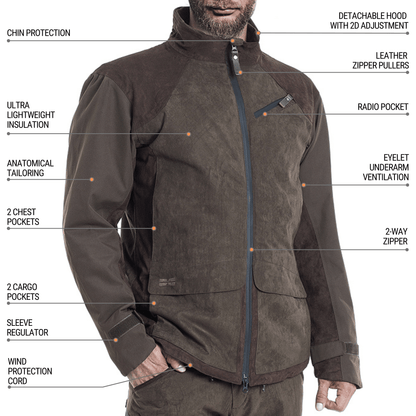 Ein Mann trägt die Hillman Jagdjacke Herren Winter - Wasserdicht & Warm | Fusion™ mit Kinnschutz, abnehmbarer Kapuze, Lederreißverschlüssen, Funkgerätetasche, Duraheat-Isolierung, Brust- und Gepäcktaschen, Cordura-Verstärkungen, Ärmelregulierung und Unterarmbelüftung.