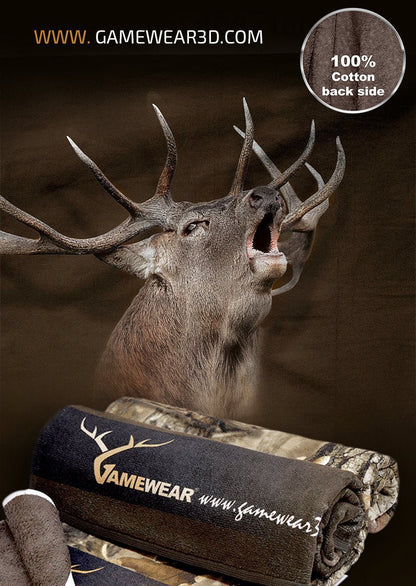 Ein röhrender Hirsch thront über zwei gerollten Tarndecken mit den Aufschriften „Gamewear“ und „gameworks3d.com“. Die Aufschrift „Rückseite 100 % Baumwolle“ vermittelt authentische Jagdatmosphäre. Produkt: Hillman® 30x50cm Duschtuch Hirsch.