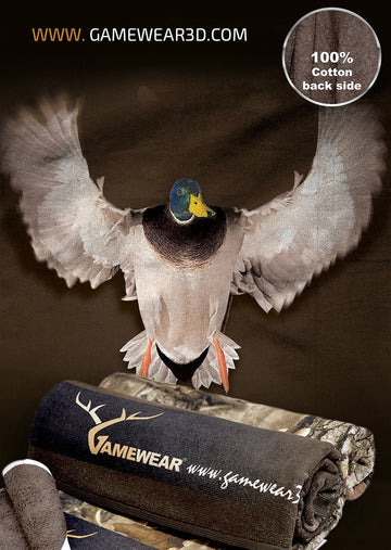 Das realistische Bild einer Stockente im Flug ist abgebildet. Darunter befindet sich ein aufgerolltes Duschtuch mit Camouflage-Muster (70 x 140 cm) von Hillman®, perfekt für eine Jagdatmosphäre, mit dem Text „Rückseite 100 % Baumwolle“ in der oberen rechten Ecke.
